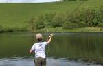 Child casting line into loch